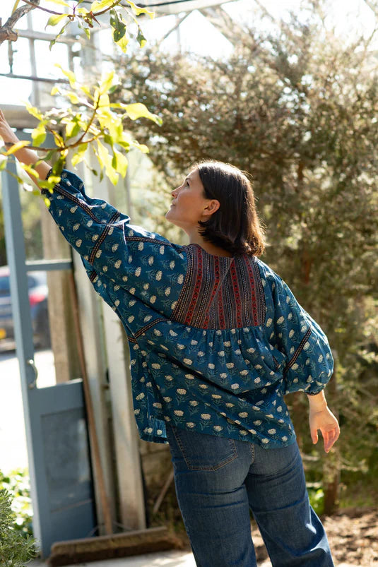Woman wearing a loose blue floral block print top
